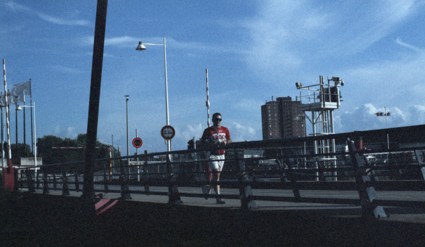 jeremy court sur un pont avec un ciel bleu